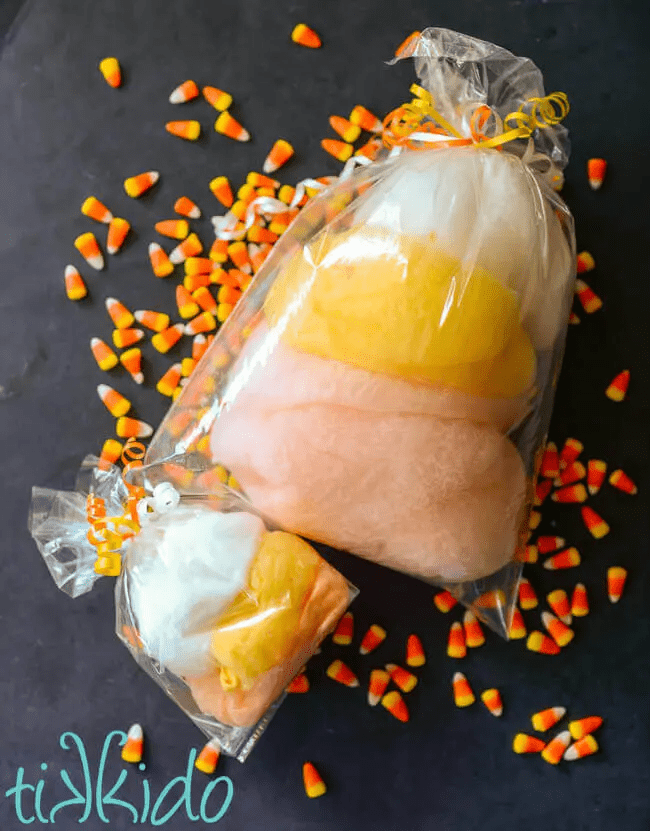orange, yellow, and white candy corn cotton candy in clear plastic bag