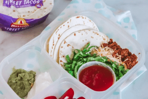 plastic meal container with taco meat, tortillas, and additions for street tacos