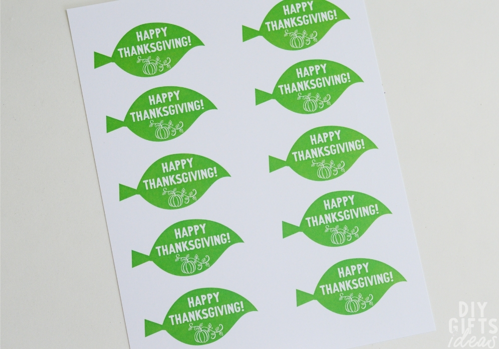 Overhead view of printable leaf tags that say "Happy Thanksgiving".