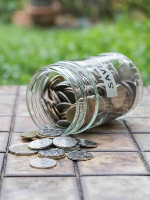 Coins spilling out of a glass bottle