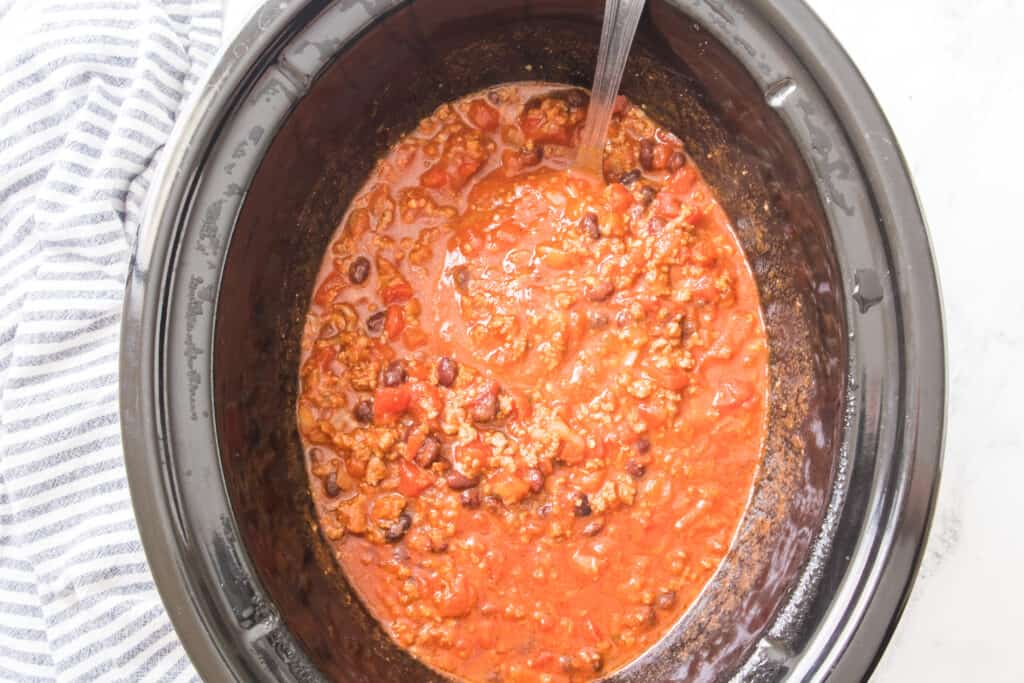 slow cooker with chili and ladle