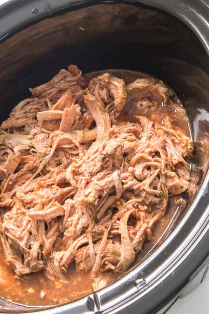shredded pulled pork with bbq sauce in slow cooker