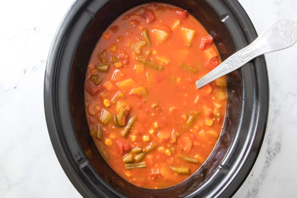 vegetable beef soup in slow cooker with ladle