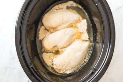 Chicken and broth cooking in a slow cooker