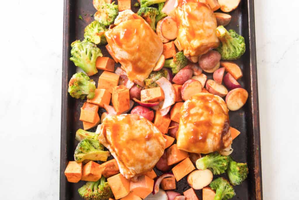 sweet potatoes, red potatoes, red onion, frozen broccoli on sheet pan with chicken thigs with bbq sauce