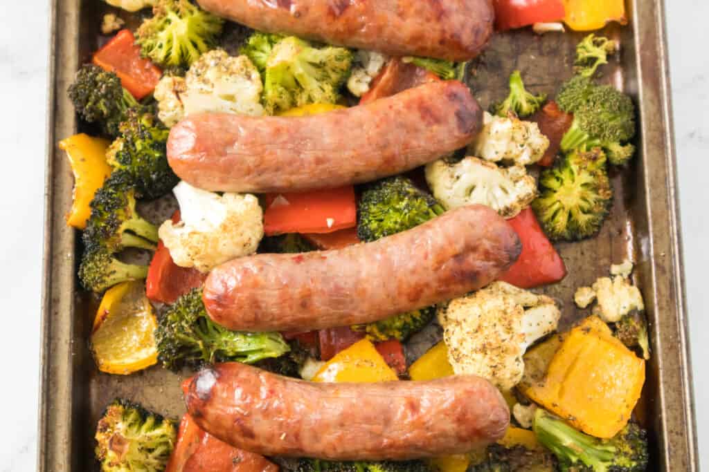 roasted veggies and Italian sausage baked on a baking sheet