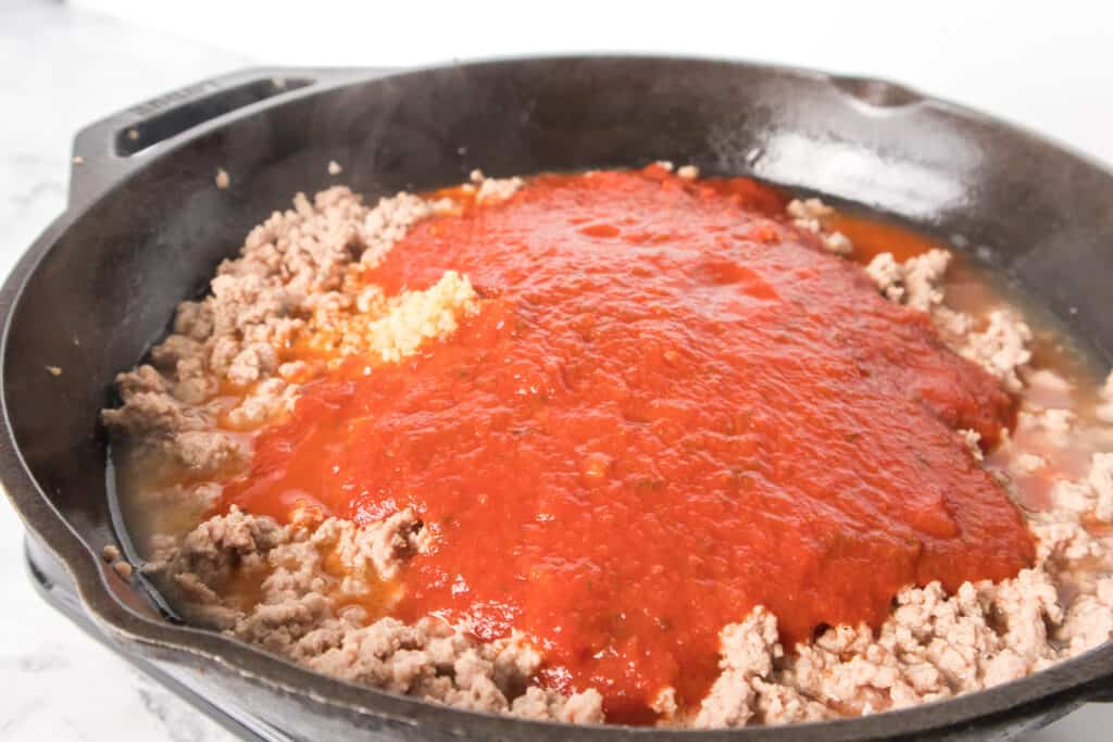 cooked ground turkey, garlic and marinara sauce in cast iron skillet