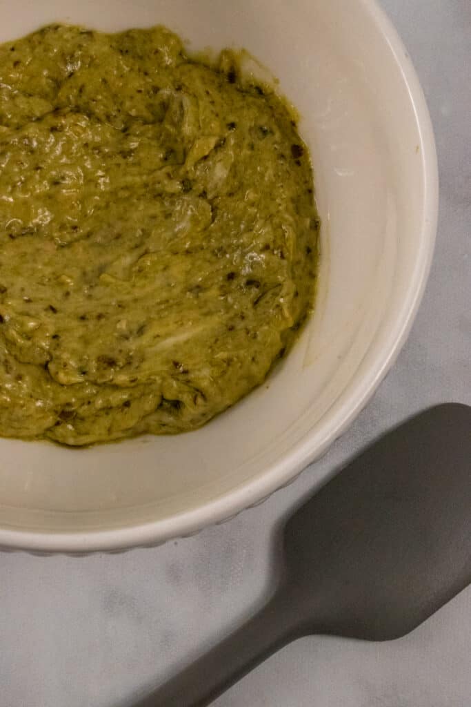 a small bowl with pesto and mayo mixed together ready to spread.