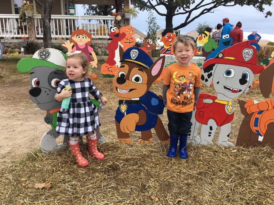 A photo of two toddlers in front of paw patrol cutouts at Flower mound pumpkin patch in fort worth. 