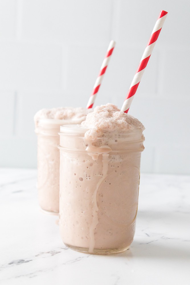 Copycat wendy's frosty in a mason jar glass with red and white striped straw. 